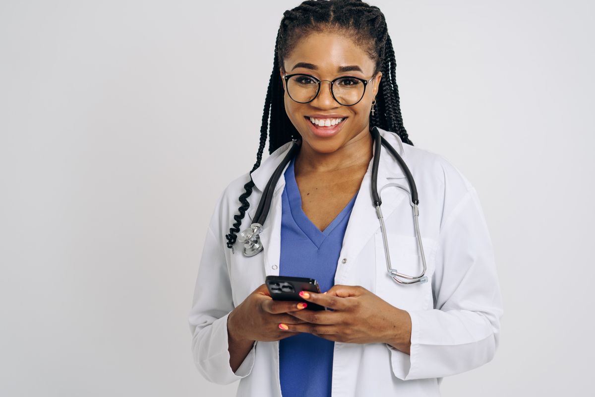 Doctor smiling while texting a referral code